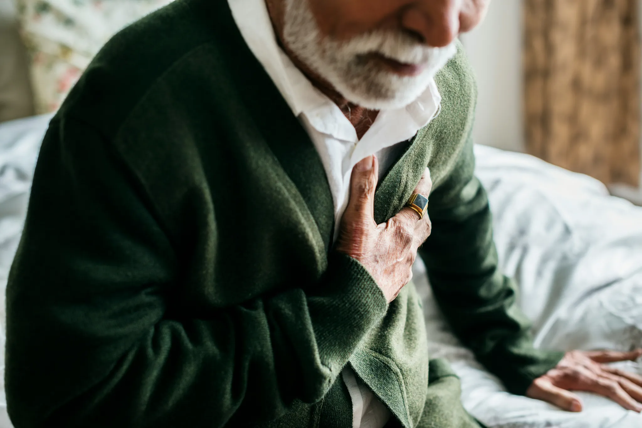 Homme âgé tenant sa poitrine, illustrant les symptômes d’un arrêt cardiaque avec douleur thoracique et malaise soudain, signe d’urgence vitale nécessitant une prise en charge immédiate.