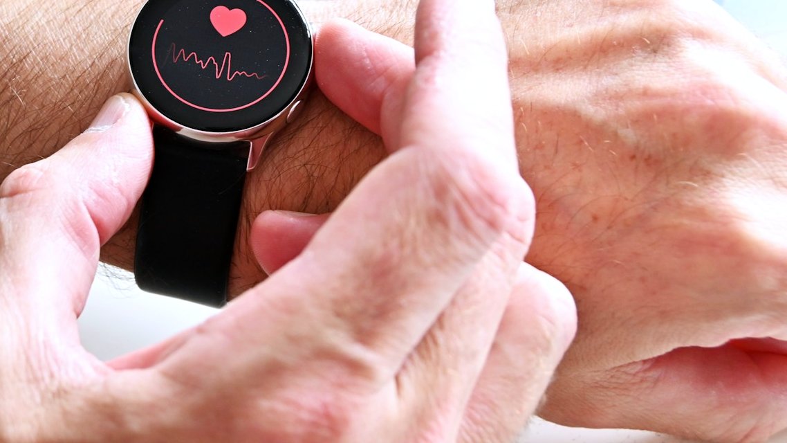 Montre connectée au poignet affichant la fréquence cardiaque (cœur et courbe de rythme)